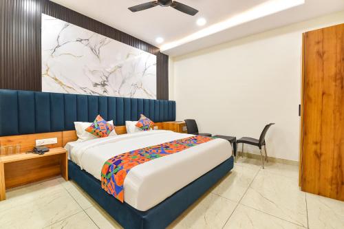 ein Schlafzimmer mit einem Kingsize-Bett mit blauem Kopfteil in der Unterkunft FabHotel D3 - Vaishali Nagar in Jaipur