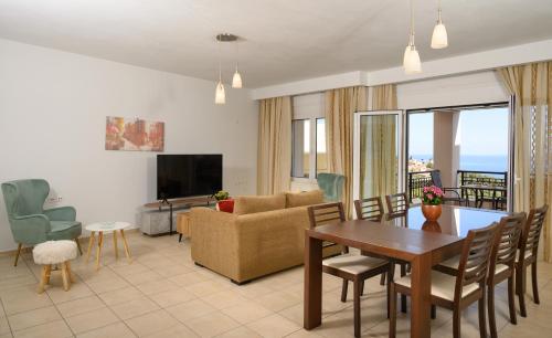 a living room with a couch and a table and chairs at Gi & Vi House in Agios Nikolaos