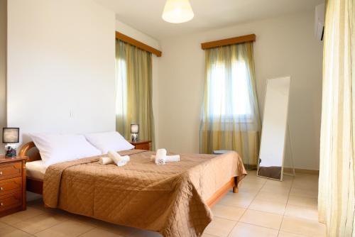 a bedroom with a bed with two towels on it at Gi & Vi House in Agios Nikolaos