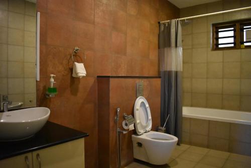 a bathroom with a toilet and a sink at Vista Del Lago - Lakeview Homestay in Ambalavayal