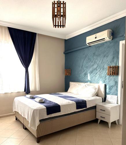 a bedroom with a bed and a blue wall at pH Ölüdeniz Suite in Fethiye
