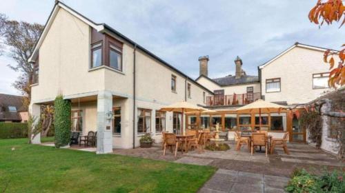 a large house with a patio with tables and chairs at Westend Hotel & Bar in Nairn