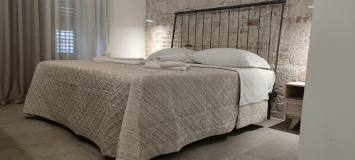 a bedroom with a large bed with two towels on it at Antica Dimora Vada' in Alberobello