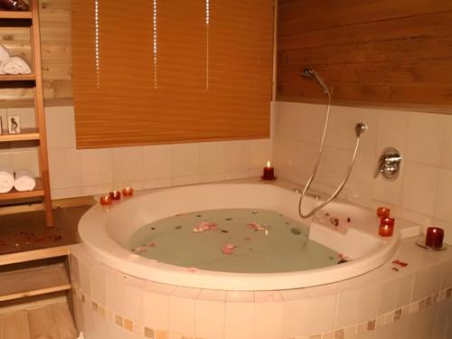 a bath tub with candles in it in a bathroom at אירוח פינת חן - מתחם אירוח מושלם עם בריכה משותפת in Ramot Naftali