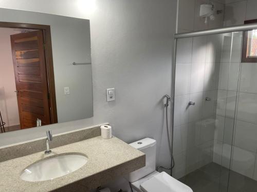 a bathroom with a toilet and a sink and a shower at POUSADA ACONCHEGO CHAPADA in Alto Paraíso de Goiás