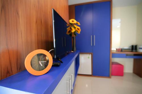 a blue counter with a fan and a vase of flowers on it at Calypso Patong Hotel in Patong Beach