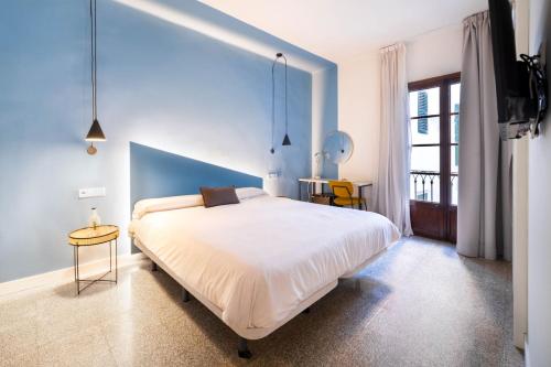 a bedroom with a large bed with a blue wall at Apuntadores 8 in Palma de Mallorca