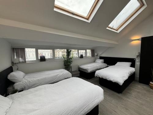 two beds in a room with windows and skylights at Williamson Suites - Apartment 2 in Liverpool
