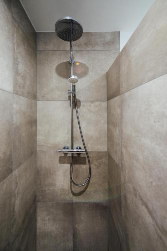 a shower with a shower head in a bathroom at Penthouse `Wolke 7` am See mit Sauna in Lembruch