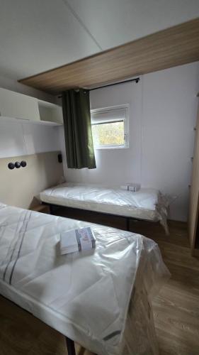 a room with two beds and a window at Mobil-home Harmonie in Gouvieux