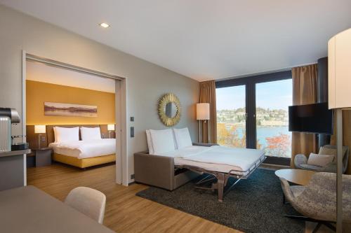 a hotel room with a bed and a couch at Radisson Blu Hotel, Lucerne in Lucerne