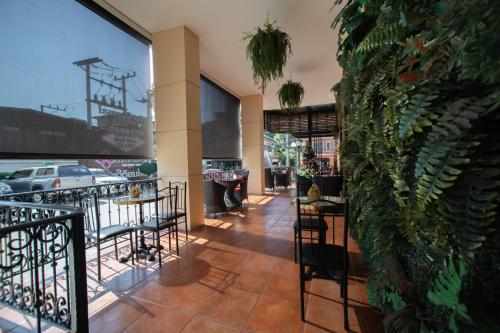 a lobby of a restaurant with chairs and plants at Banbua Grand Udon in Udon Thani