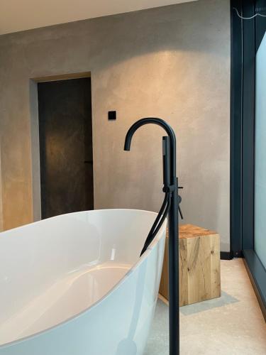 a bath tub with a faucet in a bathroom at TwoTop-Premium Chalet Villa with mountain view in Piatra Fantanele