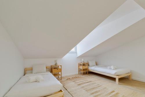 a bedroom with two beds in a attic at Moradia Bar Sela, By Home Match in Setúbal