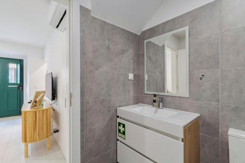 a bathroom with a sink and a mirror at Moradia Bar Sela, By Home Match in Setúbal