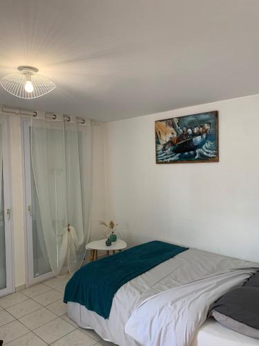 a bedroom with a bed and a picture on the wall at Le Studio du centre - 2-4p - 80 m de la plage in Les Sables-d'Olonne