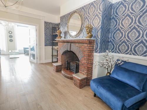 a living room with a brick fireplace with a mirror at Vista Mare 1 in Weymouth