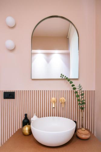 a bathroom with a large white tub on a counter with a mirror at Hotel Touring in Bologna