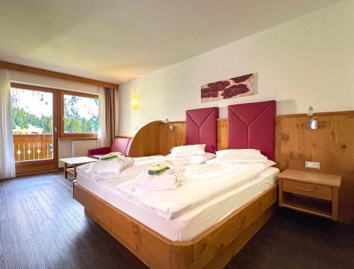 a bedroom with a large bed in a room at Garni Hotel Bel Vert in Selva di Val Gardena