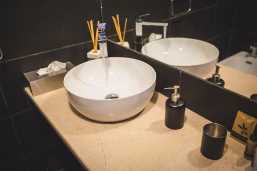 a bathroom with a large white sink and a mirror at Diomede Rooms - Manfredi Homes&Villas in Manfredonia