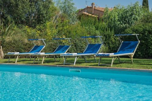 three blue chairs sitting next to a swimming pool at Agriturismo Bandinelli in Castiglione della Pescaia