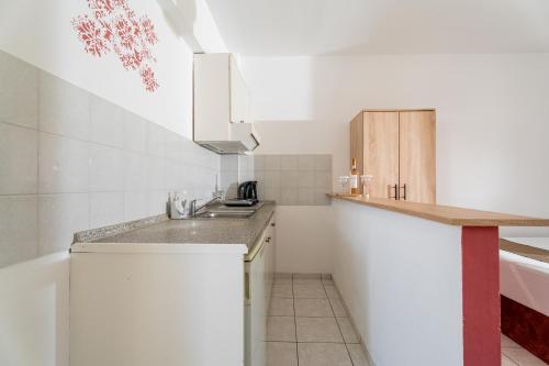 a small kitchen with white cabinets and a sink at Chrissi Ammoudia in Toroni