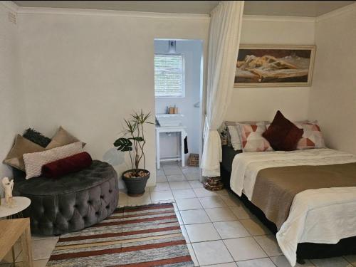 a bedroom with a bed and a chair and a table at Escape Root in Caledon