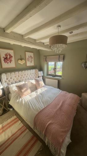 a bedroom with a large bed and a chandelier at Spenford House 1640 listed house Idilic Location pub walking distance in Shrewsbury