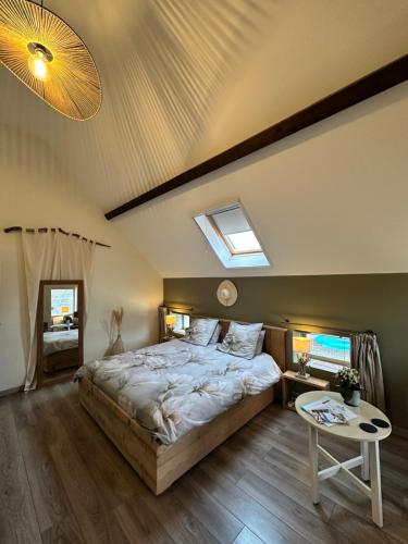 a bedroom with a large bed and a skylight at Chambres d'Hôtes Maison Balady in Bellenaves