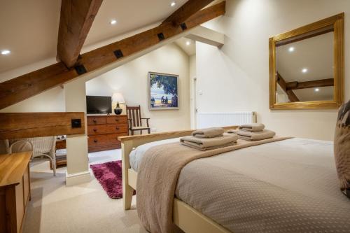 a bedroom with a large bed and a mirror at Rose Barn in Hawkshead
