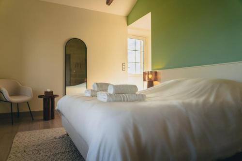 a bedroom with a large white bed with pillows on it at Château La Voûte in Saint-Étienne-de-Lisse