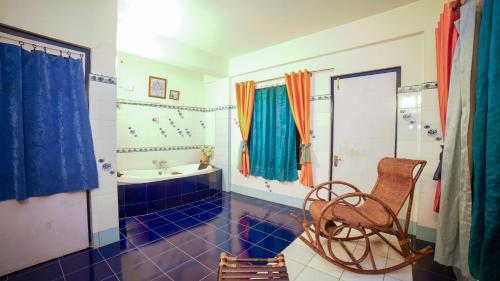 a bathroom with a tub and a chair in it at Bamboo Retreat Hotel in Gangtok