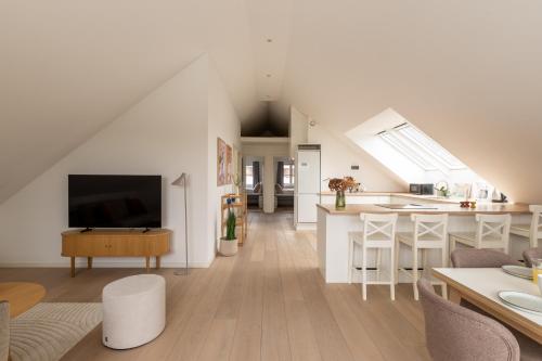 a white living room with a kitchen and a living room at Sunlit Loft Apartment in Valby with Parking for 8 in Copenhagen