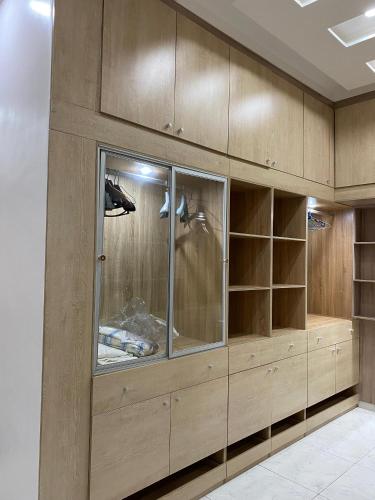 a closet with wooden cabinets and glass doors at Le grand luxe in Cotonou