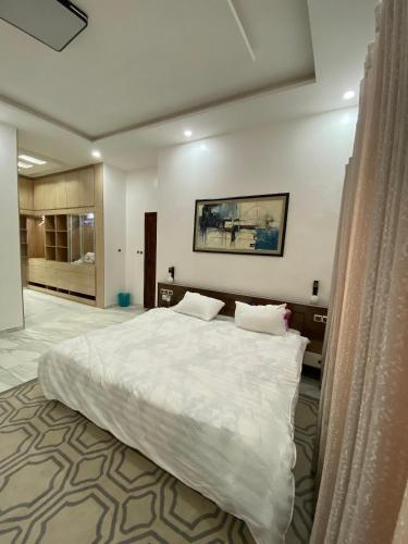 a bedroom with a large white bed in a room at Le grand luxe in Cotonou