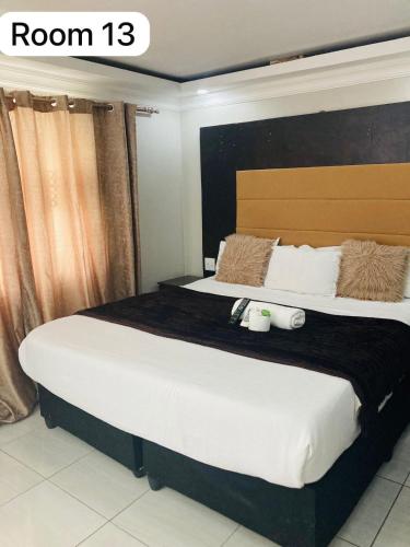 a bedroom with a large bed with a large headboard at The Bright Guest House in Pretoria