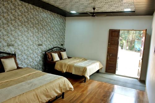 a room with two beds and a door to a courtyard at Nivant Agro Experience in Gorhe