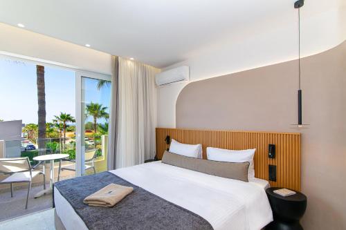 ein Schlafzimmer mit einem großen Bett und einem Balkon in der Unterkunft Aeolos Beach Resort in Malia