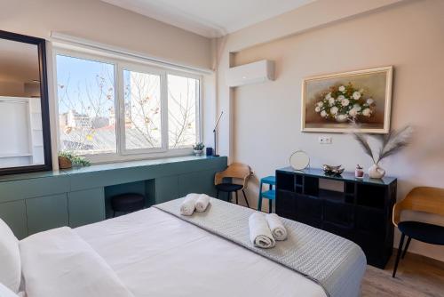 una camera da letto con un letto con asciugamani sopra di TsakOne Downtown ad Atene