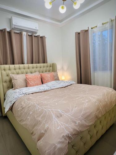 a bedroom with a large bed with pink pillows at Serenity Stay in General Santos