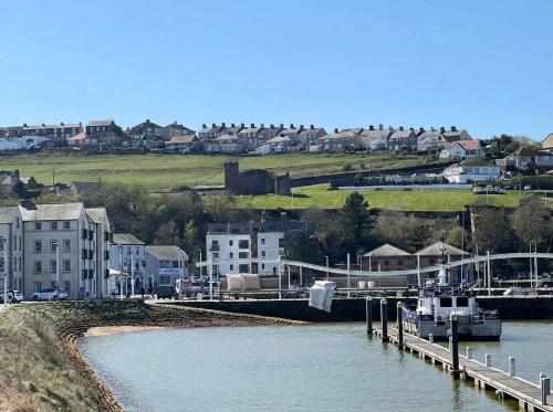 a boat is docked at a dock in a harbor at Bright 1 Bed Harbour-side Apartment with Balcony in Whitehaven