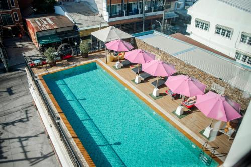 an overhead view of a swimming pool with pink umbrellas at Banbua Grand Udon in Udon Thani