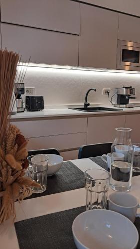 a kitchen with a table with plates and glasses on it at Chalet La coccola di Lulù in Molina di Ledro