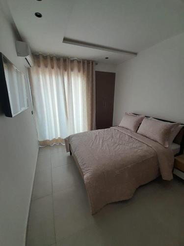 a bedroom with a large bed and a large window at Al Anouar 39B in Kenitra