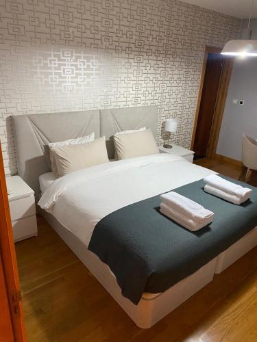 a bedroom with a large bed with two towels on it at House Infantado Loures in Loures