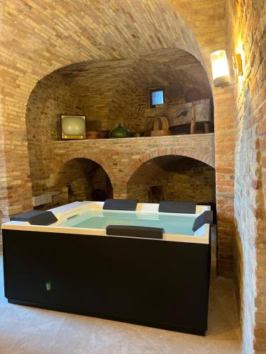 a room with a table in a brick wall at Dimora Santa Chiara in Ripatransone
