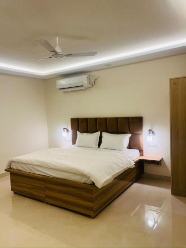 a bedroom with a bed and a ceiling fan at Greek House By Housiify in Gurgaon