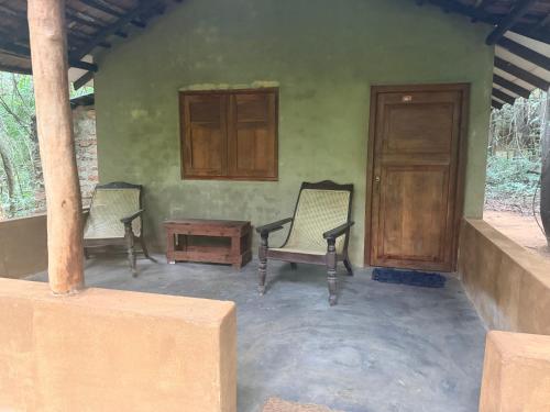 a room with two chairs and a table and a door at Kamatha Eco Lodge in Habarana