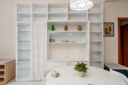 a white room with a table and shelves at San Menaio Apartment by Rentbeat in San Menaio