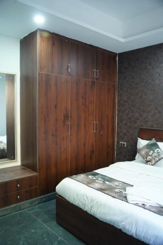 a bedroom with wooden cabinets and a bed at Rudra Homestay - Rishikesh in Rishīkesh